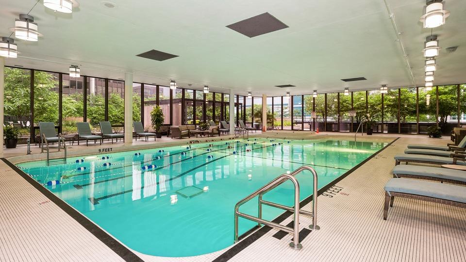 Indoor swimming pool area with large windows, lounge chairs, and a marked depth of 3 feet.