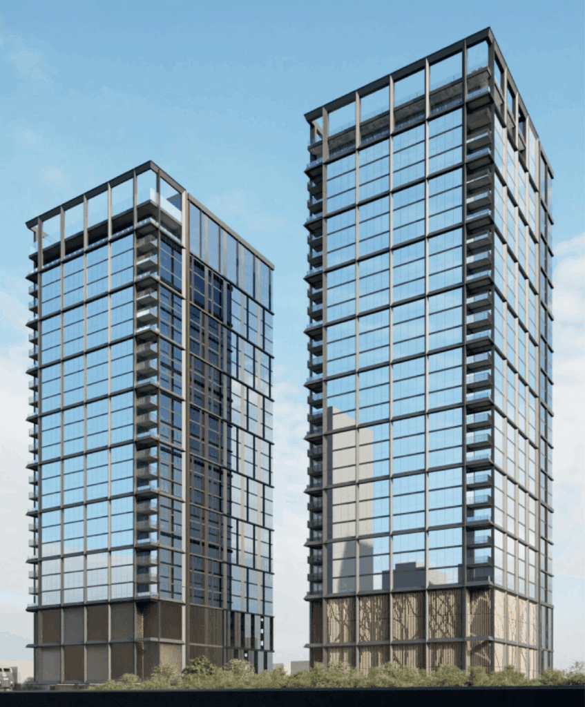 Two modern high-rise buildings, including 400 N Elizabeth, with glass facades stand side by side under a clear blue sky, reflecting surrounding structures.