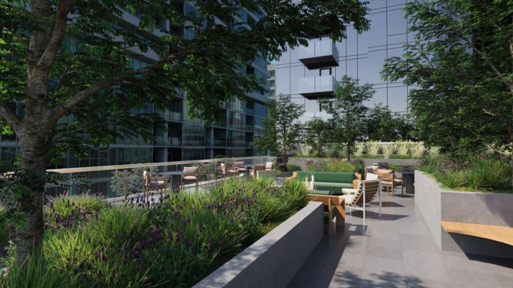 Outdoor terrace with seating areas, trees, and greenery, adjacent to a modern glass building with balconies. Several people are seated, enjoying the space.