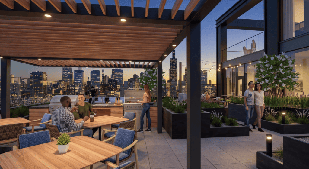 People socialize and dine on a modern rooftop patio with outdoor furniture, a grill, plants, and city skyscrapers visible in the background at dusk.