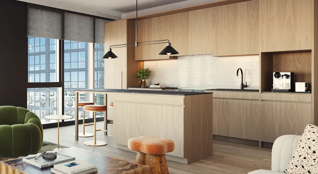 Modern kitchen with light wood cabinets, a large island, bar stools, pendant lights, and a window with a city view. Part of a green chair and marble coffee table are visible in the foreground.